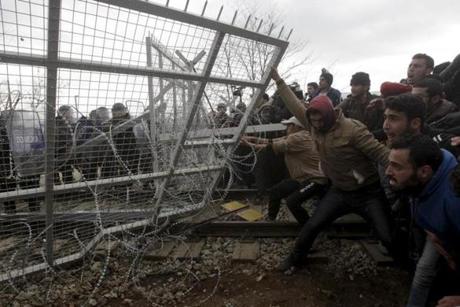 Refugees and migrants near the Greek village of Idomeni tried to bring down part of a fence Monday at the Macedonian border