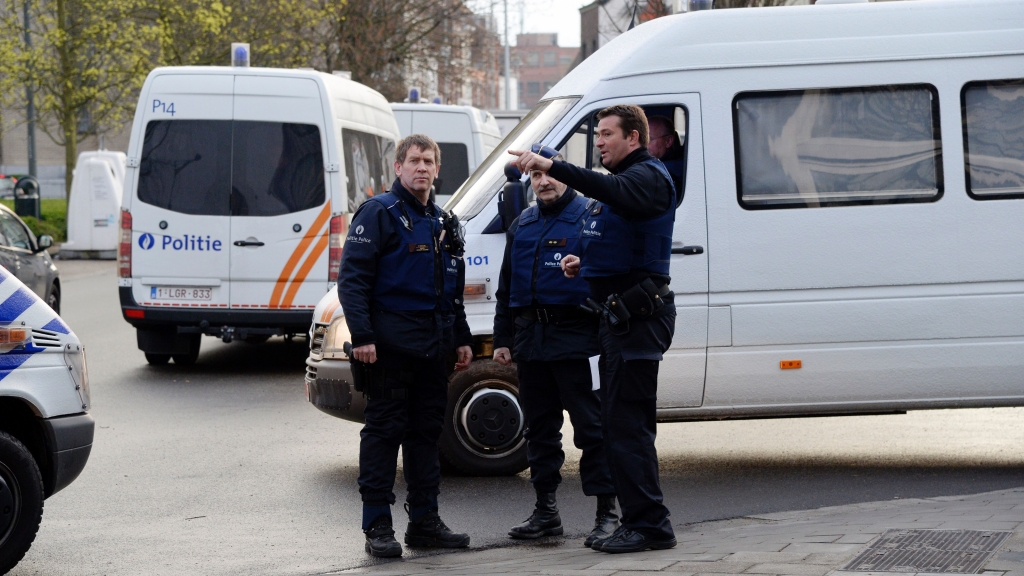 Belgian police officers stand in Albert I square in Brussels where authorities arrested Mohamed Abrini a key Paris attacks suspect on Friday