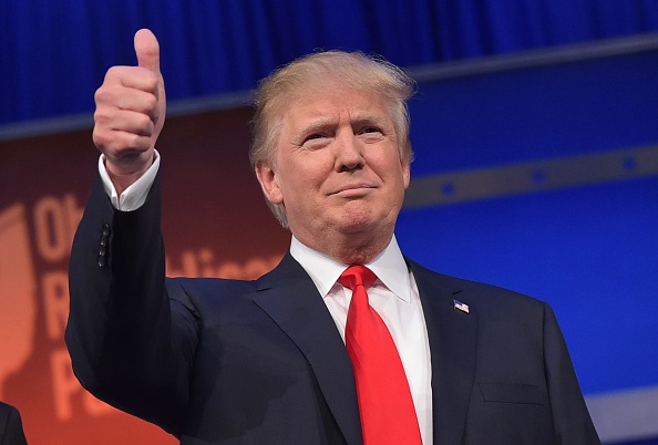 Real estate tycoon Donald Trump flashes the thumbs-up as he arrives on stage for the start of the prime time Republican presidential debate