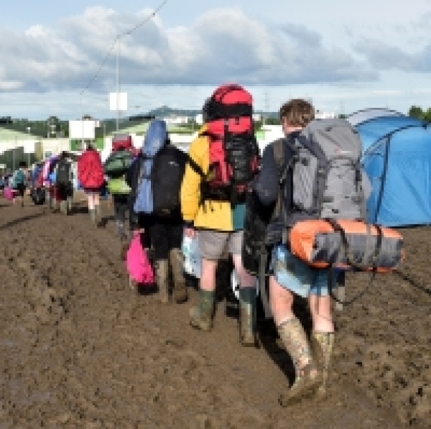 A festivalgoer walks through the aftermath of the final night at Worthy Farm in Somerset