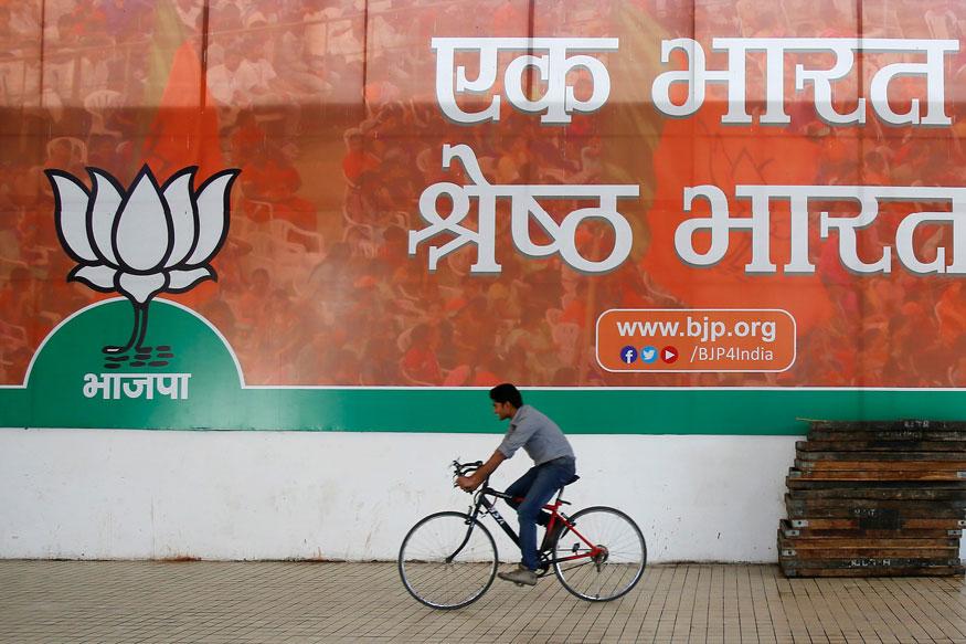 A man cycles pasts a BJP banner