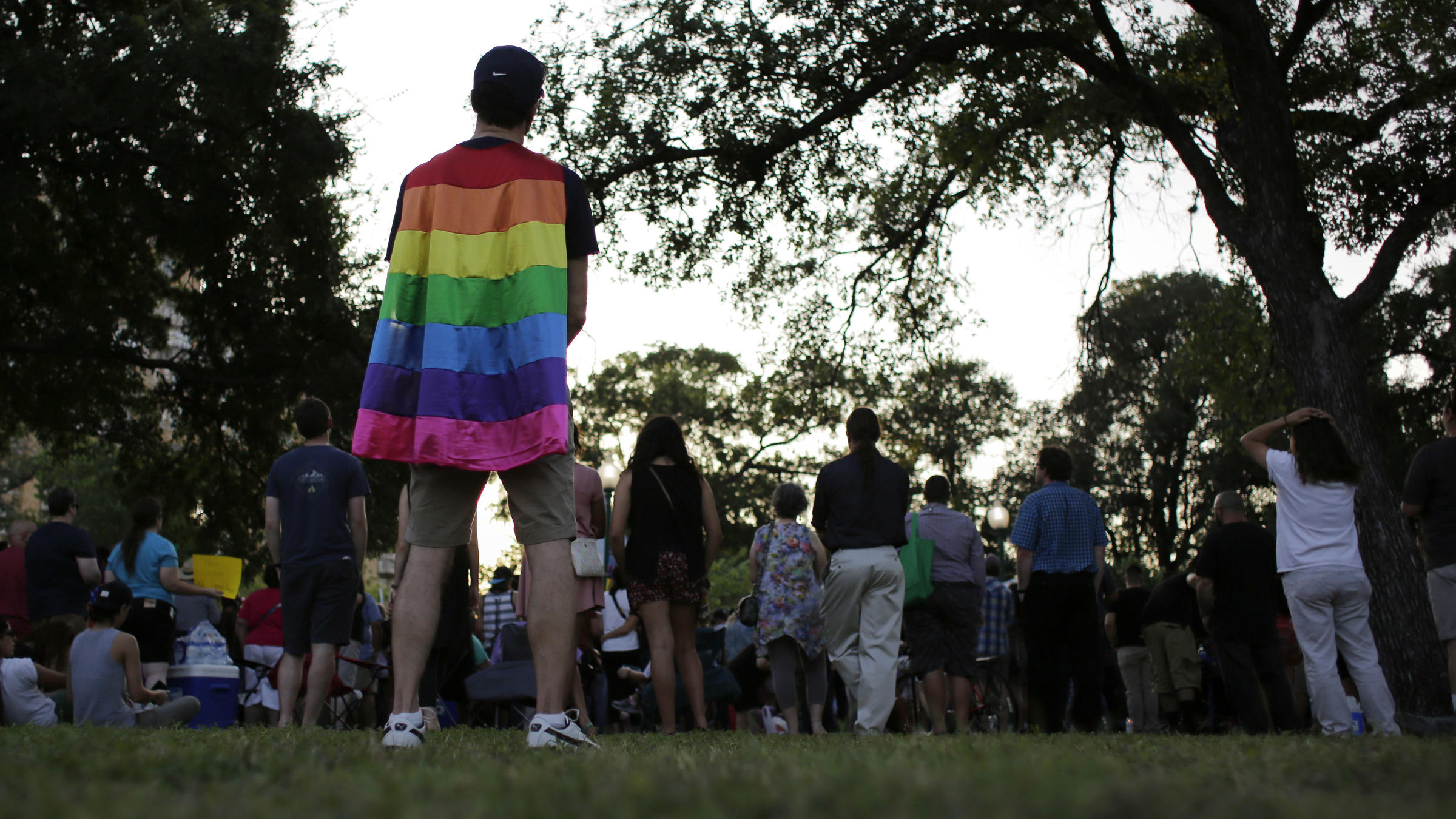 A man wears a rainbow cape during a memorial vigil for the victims of Orlando's Pulse nightclub shooting Thursday in San Antonio