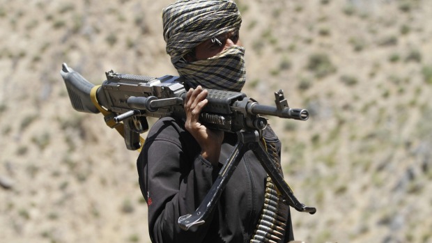 A member of a breakaway faction of the Taliban fighters guards a gathering in Shindand district of Herat province