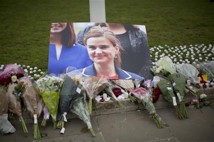 An image and floral tributes for Jo Cox the 41-year-old British Member of Parliament shot to death in northern England lie placed on Parliament Square outside the House of Parliament in London Friday