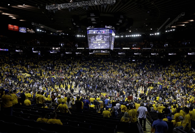 Fans at Oracle Arena watch as Cleveland Cavaliers players celebrate after Game 7 of basketball's NBA Finals between the Golden State Warriors and the Cavaliers in Oakland Calif. Sunday