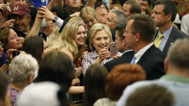 Democratic presidential candidate Hillary Clinton takes a selfie with supporters at a rally at Sacramento City College Sunday