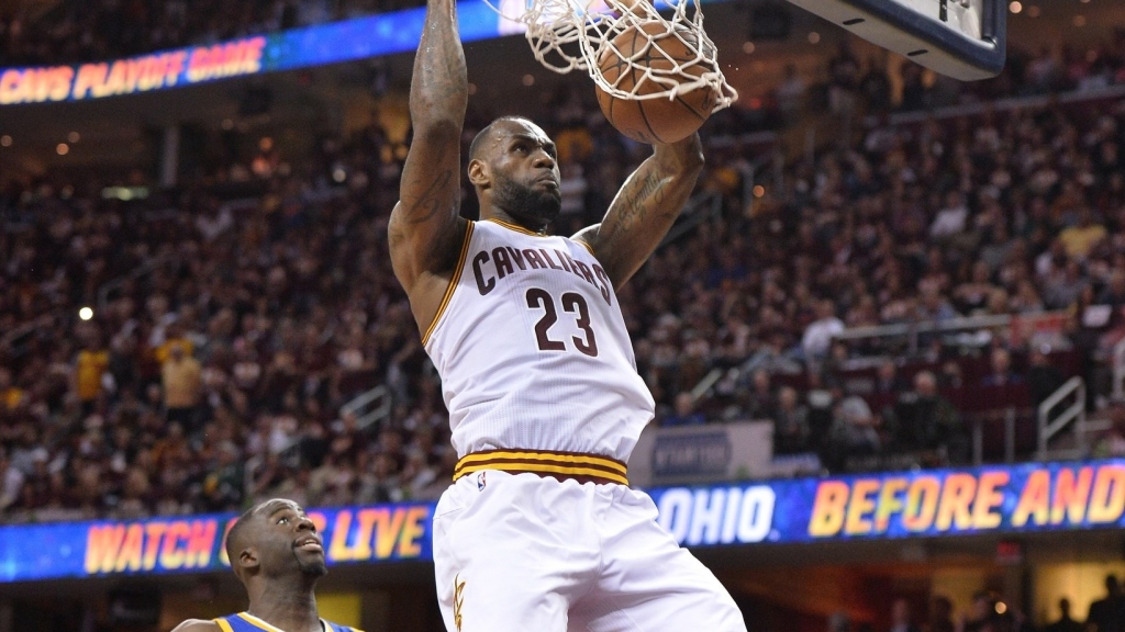 Cleveland Cavaliers forward Le Bron James dunks the ball in front of Golden State Warriors forward Draymond Green