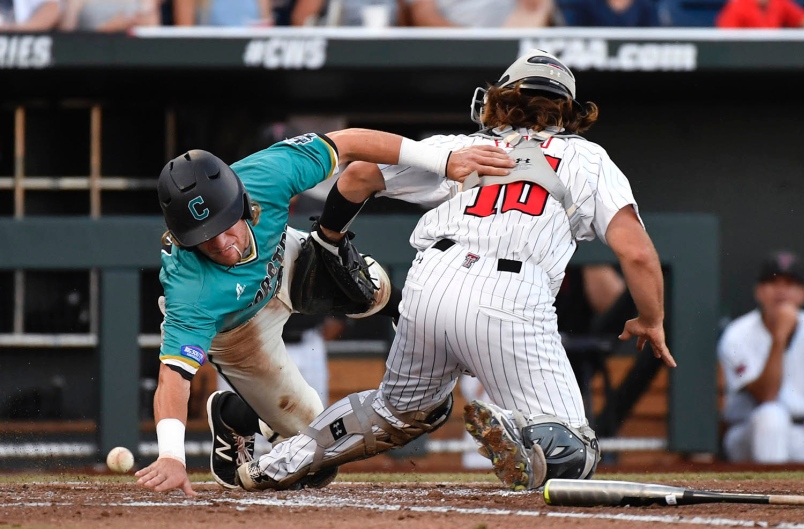 Coastal Carolina's Zach Remillard left reaches to score around Texas Tech catcher Tyler Floyd as the ball gets away during the third inning of Thursday's elimination game at the College World Series in Omaha