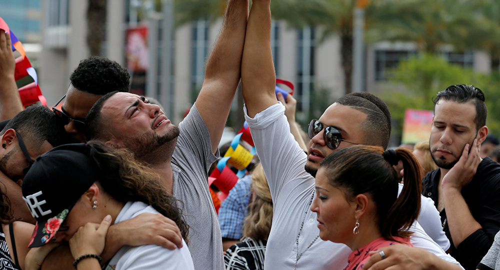 Mourners grieve at a vigil for the victims of the shooting at the Pulse gay nightclub in Orlando Florida