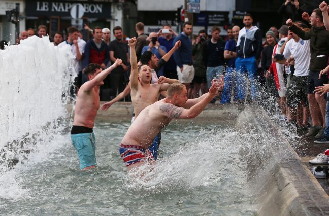 England fans celebrate in a fountain outside the train station in Lille