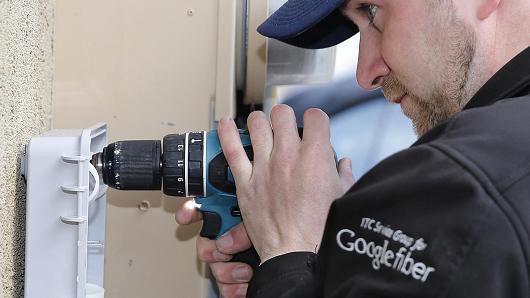 A Google Fiber technician installs a fiber optic box at a residential home as part of Google Fiber services in Provo Utah. Google Fiber is now be headed to Dallas