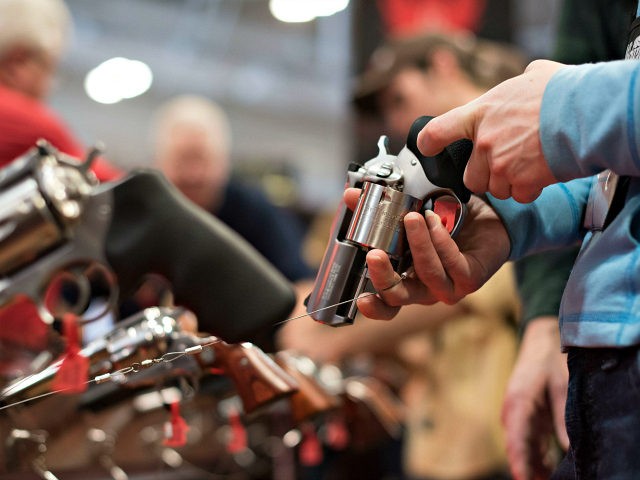 An attendee handles a revolver in the Sturm Ruger & Co. Inc. booth on the exhibition floor of the 144th National Rifle Association Annual Meetings and Exhibits at the Music City Center in Nashville Tennessee U.S. on Saturday