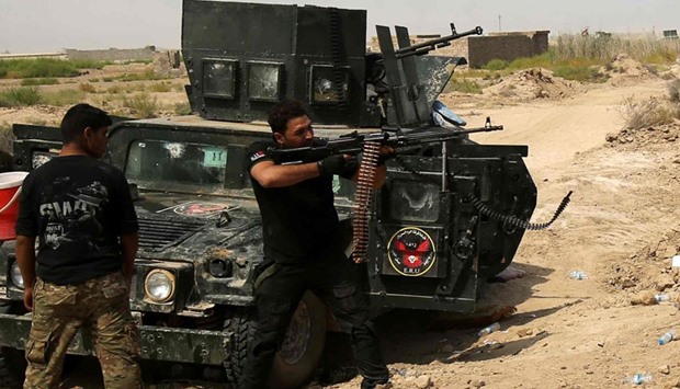 A member of Iraqi government forces aims his machine gun during an operation in Fallujah's Shuhada