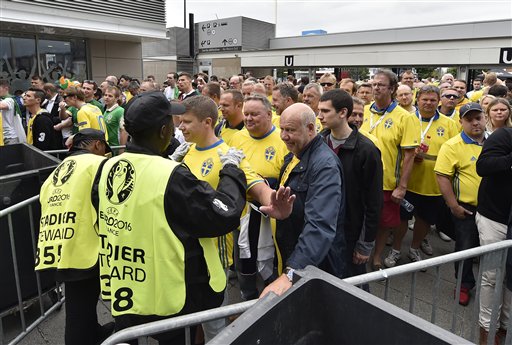 Spectators go through security checks as they enter the stadium prior to the Euro 2016 Group E soccer match between Ireland and Sweden at the Stade de France in Saint-Denis north of Paris France Monday