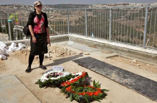 An Israeli woman mourns next to the graves of Eitam and Naama Henkin in Jerusalem's cemetery