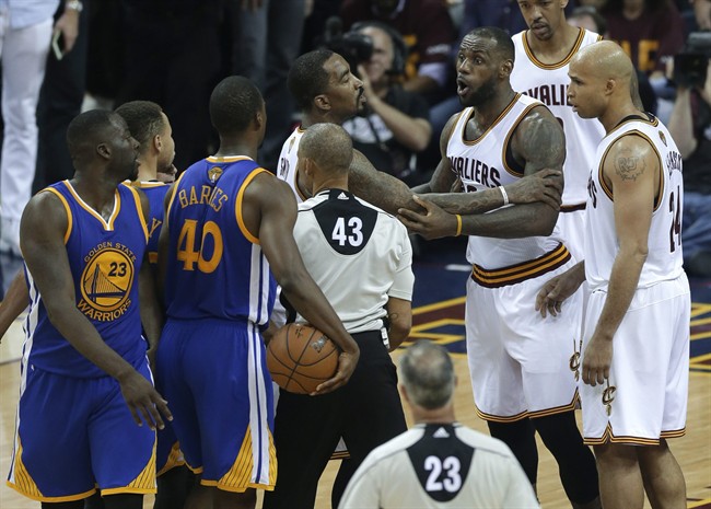 Cleveland Cavaliers forward Le Bron James is held back as he argues with Golden State Warriors forward Draymond Green during the second half of Game 4 of basketball's NBA Finals in Cleveland Friday