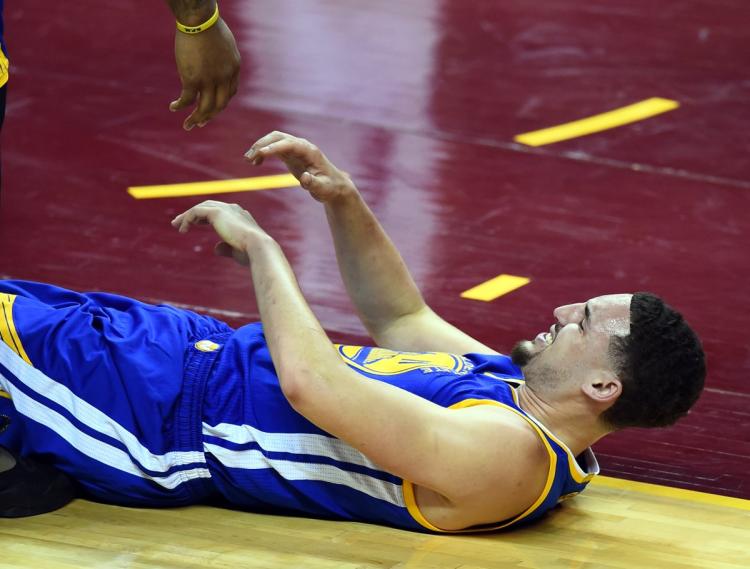 Klay Thompson hits the deck after taking a knee to the thigh from Timofey Mozgov