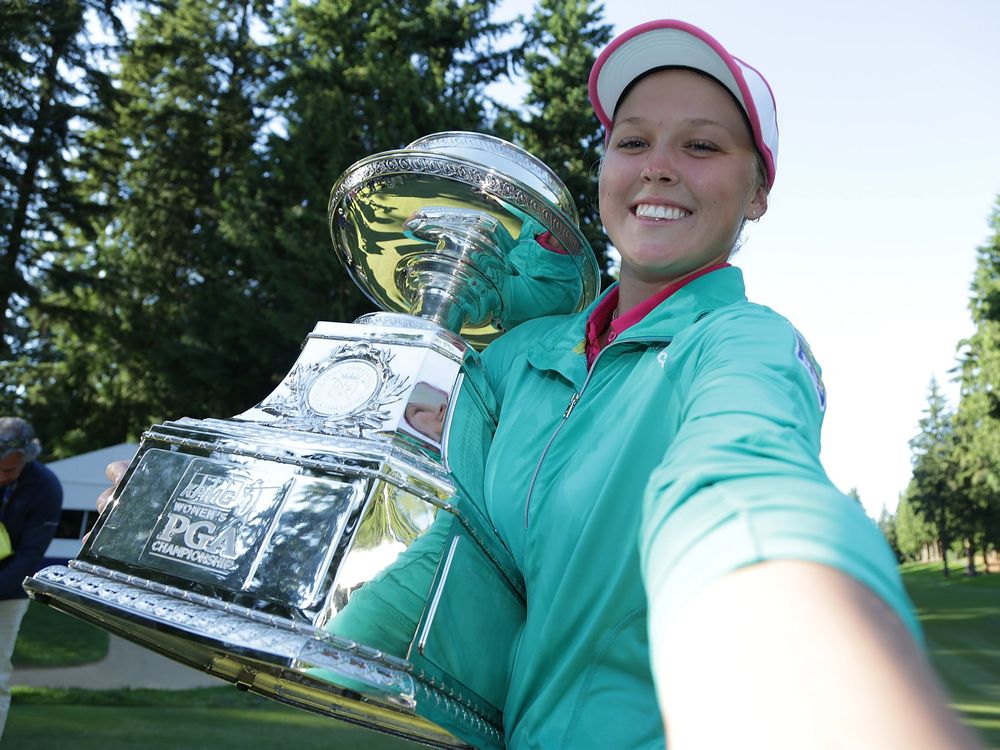 Brooke Henderson of Canada poses for a simulated selfie with the trophy after winning the KPMG Women's PGA Championship in a playoff against Lydia Ko at Sahalee Country Club earlier this month in Sammamish Washington