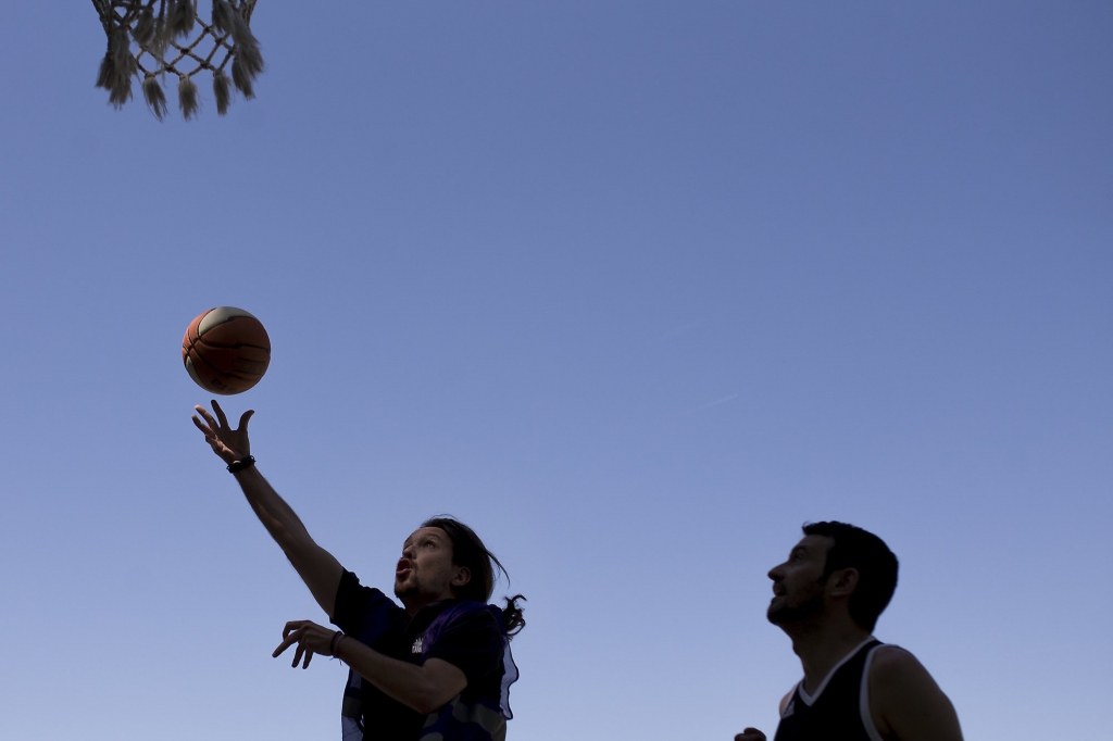 Spain's Unidos Podemos coalition party leader Pablo Iglesias left goes with the ball to the basket during a basketball match with some friends at the Complutense University of Madrid sports campus in Madrid Saturday