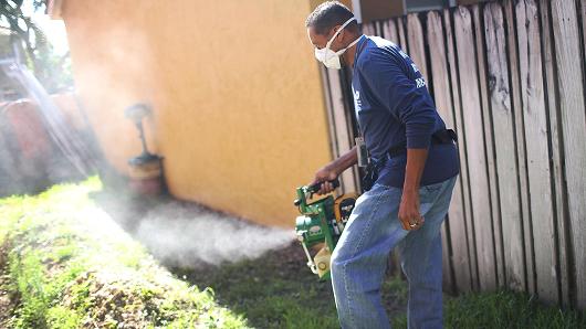 A Miami Dade County mosquito control inspector uses a fogger to spray pesticide to kill mosquitos as the county continues to fight a possible Zika virus outbreak