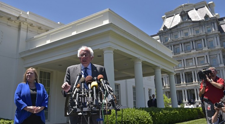 Democratic presidential candidate Bernie Sanders speaks to the press outside of the West Wing as his wife Jane O'Meara Sanders looks on following a meeting with US President Barack Obama