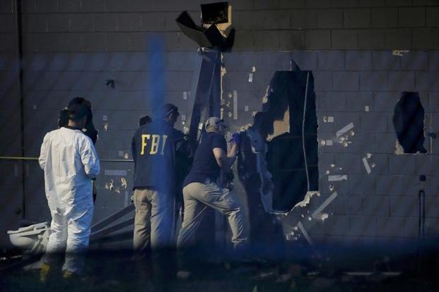 Forensic investigators work at the crime scene of a mass shooting at the Pulse gay night club in Orlando Florida