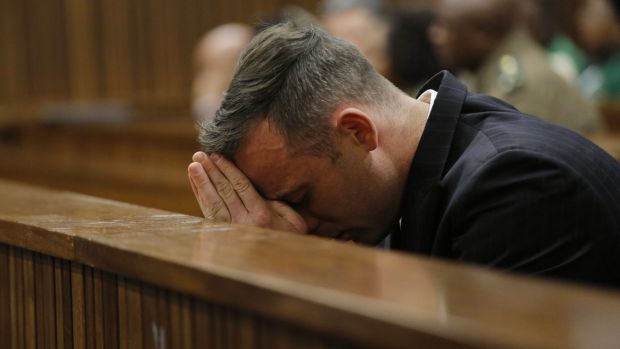 Oscar Pistorius puts his head in his hands as he sits inside the dock at the high court in Pretoria