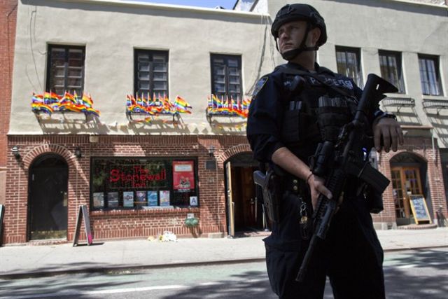 An armed police officer stands guard outside the Stonewall Inn Sunday in New York