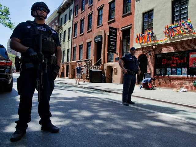 Police officers stand guard outside the Stonewall Inn Sunday