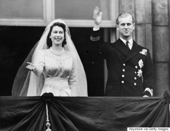 Queen Elizabeth and The Prince Philip Duke of Edinburgh waving to a crowd from the balcony of Buckingham Palace