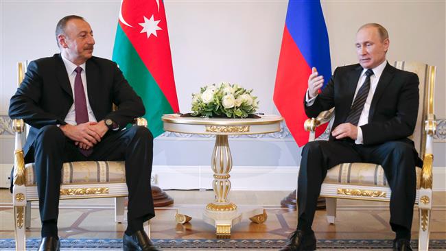 Russian President Vladimir Putin speaks with Azerbaijan's President Ilham Aliyev during their meeting in Saint Petersburg