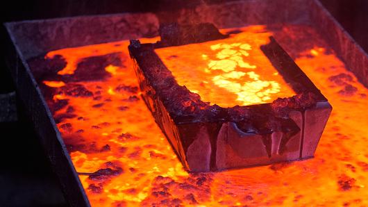 A casting mold filled with molten gold sits above a melting vat during the manufacture of gold ingots at the Suzdal gold mine operated by Nordgold NV in Semey Kazakhstan