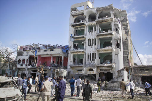 Security forces examine the scene after a bomb attack on Ambassador Hotel in Mogadishu Somalia Thursday