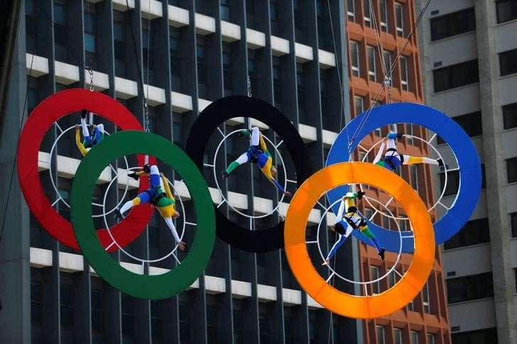 Acrobats perform on the Olympics rings at Paulista Avenue in Sao Paulo's financial center Brazil