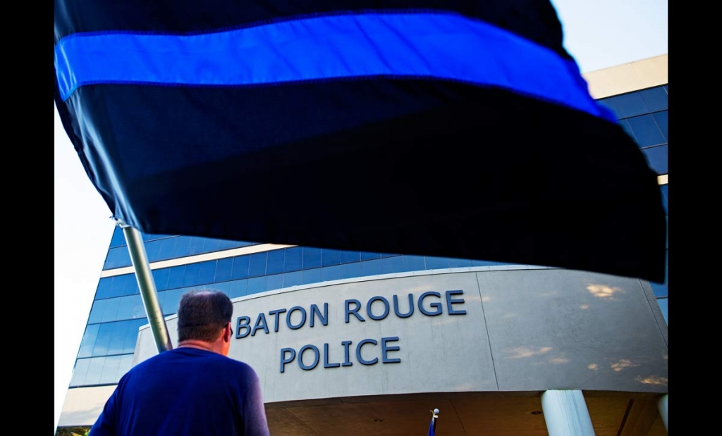 Brian Armoney of Baton Rouge holds a flag following a'Law Enforcement Support ride in front of the Baton Rouge Police headquarters in Baton Rouge La. Tuesday