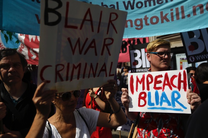 Protesters hold placards outside the Queen Elizabeth II Conference Centre in London shortly before the publication of the Chilcot report into the Iraq war