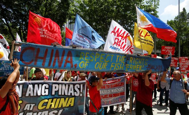 Demonstrators display a part of a fishing boat with anti China protest signs during a rally outside the Chinese Consulate in Makati City