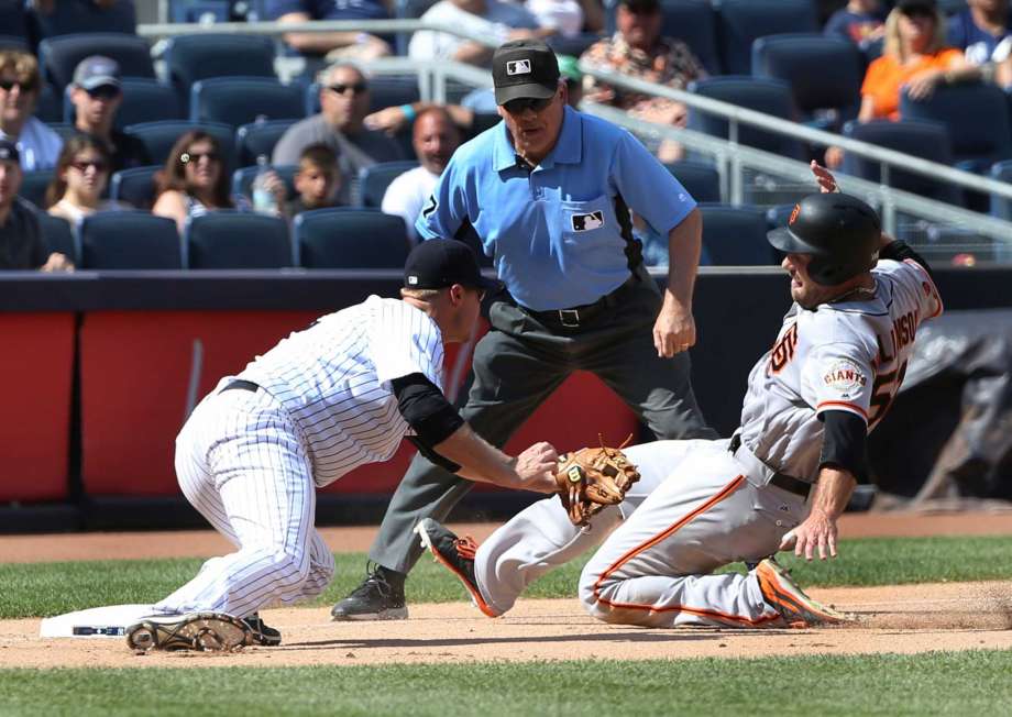 New York Yankees third baseman Chase Headley left completes a double play by tagging out San Francisco Giants Mac Williamson at third base during the eighth inning of the baseball game at Yankee Stadium Sunday