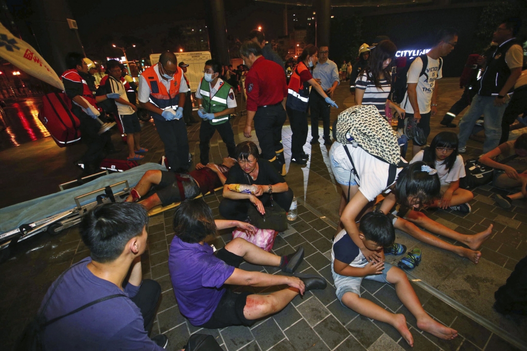 Injured people are helped by emergency rescue workers outside a station after an explosion on a passenger train in Taipei Taiwan Thursday