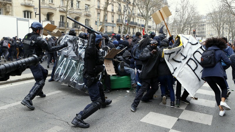 Youths clash with riot police officers during a high school students demonstration against a labor reform in Paris Thursday