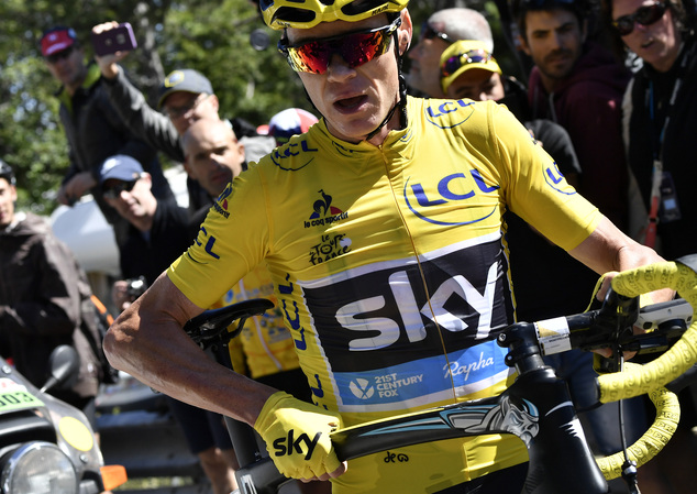 Britain's Chris Froome wearing the overall leader's yellow jersey runs with his bike after a crash at the end of the twelfth stage of the Tour de France cyc