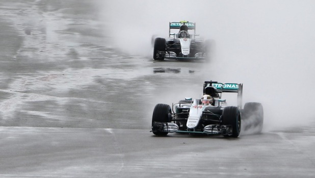 Mercedes driver Lewis Hamilton leads teammate Nico Rosberg in the rain during the British Formula One Grand Prix at the