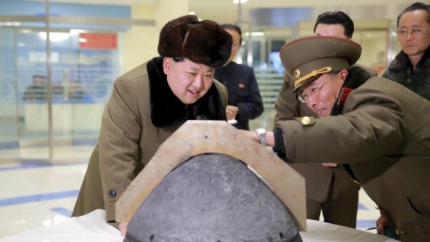 North Korean leader Kim Jong Un looks at a rocket warhead tip after a simulated test of atmospheric re-entry of