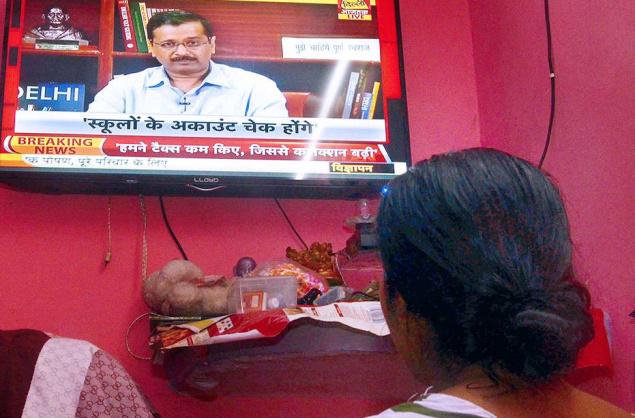 A Delhi resident watching the live telecast of Chief Minister Arvind Kejriwal on Sunday