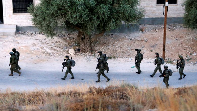 Israeli forces patrol near the house where Hamas fighter Mohammad al Fakih was shot dead by Israeli troops during a raid in the West Bank village of Surif near Hebr