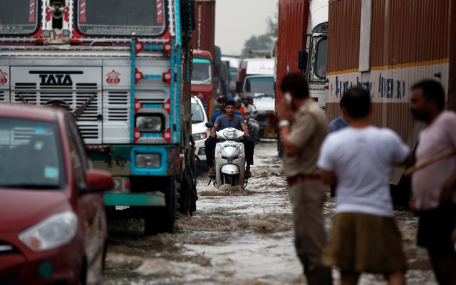 Vehicles wade through a waterlogged highway after heavy rains in Gurugram previously known as Gurgaon on the outskirts of New Delhi India