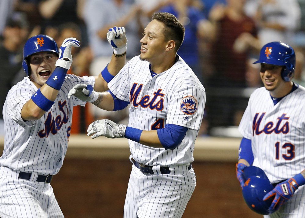 Brandon Nimmo left Wilmer Flores center and Asdrubal Cabrera of the Mets celebrate after scoring on Flores pinch-hit three-run homer against the Nationals at New York on Thursday