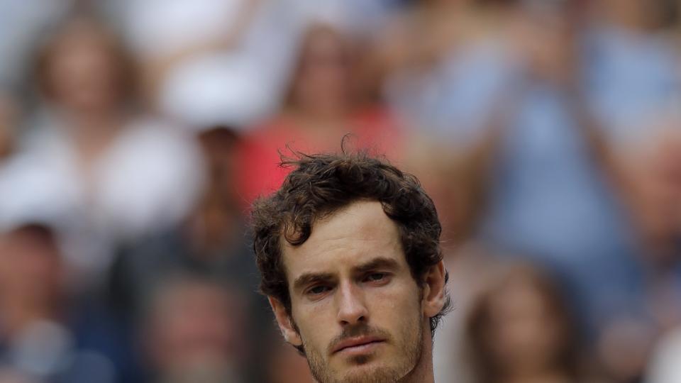 Andy Murray of Britain holds his trophy after beating Milos Raonic of Canada in the men's singles final on day fourteen of the Wimbledon Tennis Championships in London Sunday