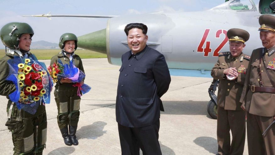 North Korean leader Kim Jong Un smiles as he attends a flight training session by female fighter pilots Jo Kum Hyang and Rim Sol in this undated