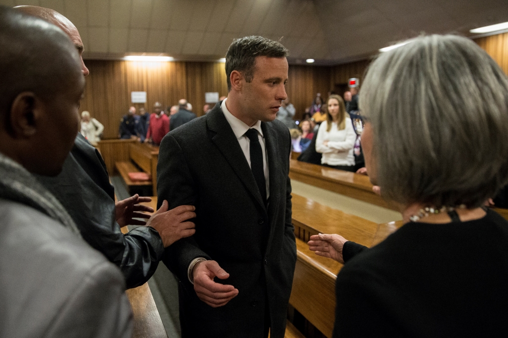 Olympic athlete Oscar Pistorius speaks with relatives after sentencing at the High Court in Pretoria South Africa